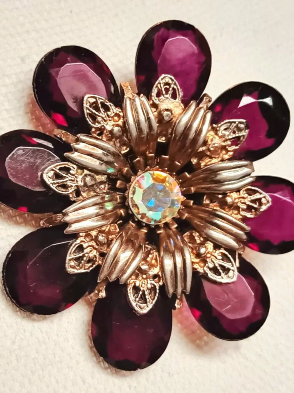 Vintage ruby lucite brooch with aurora borealis central rhinestone.